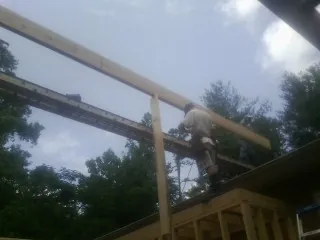 Carpenter setting a ridge beam over a new addition frame — Ice Dam Removal by Roofing Brothers in Park Rapids
