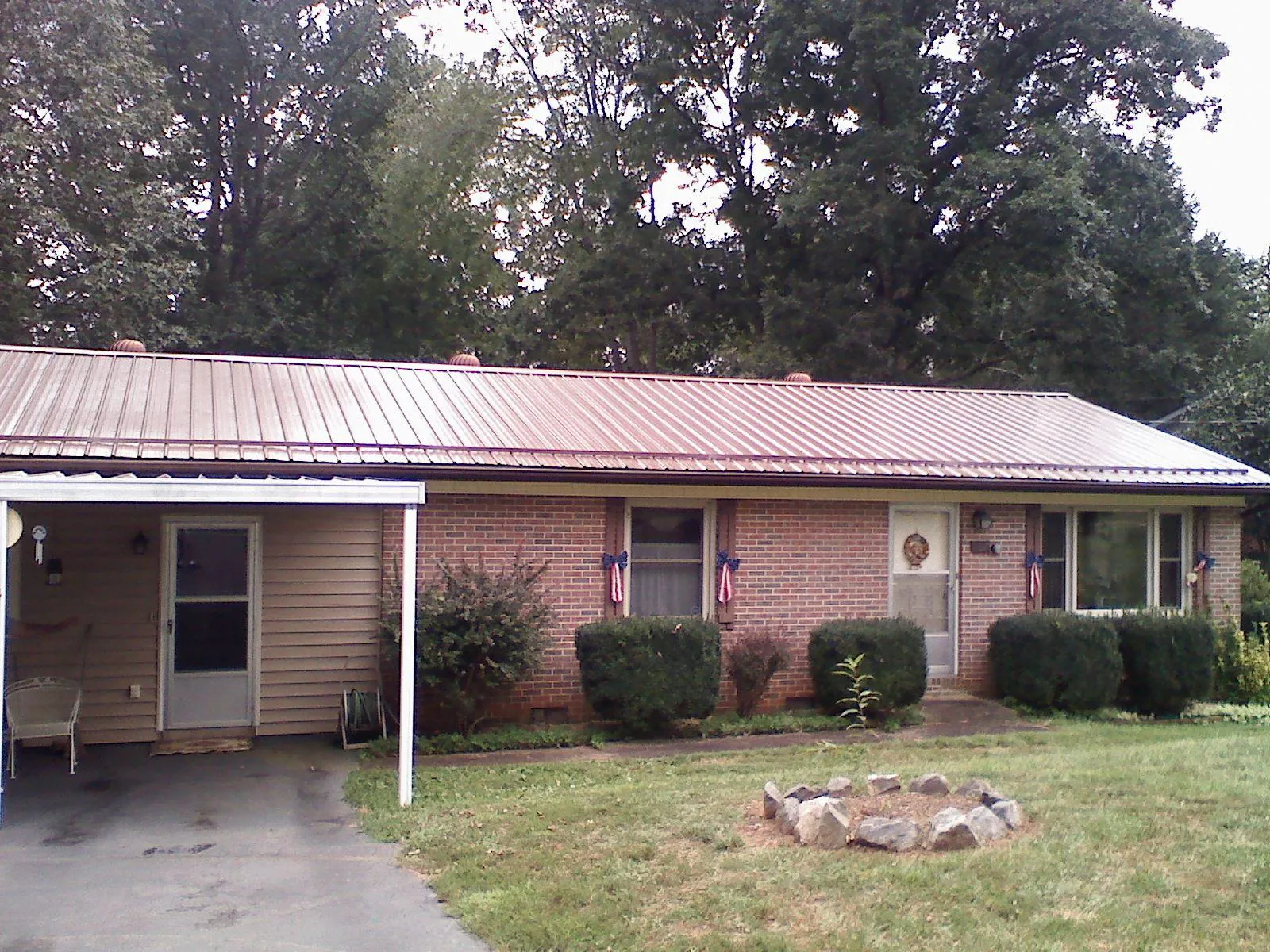 Bronze metal roof and carport on a brick ranch home — Roof Repair work by our crew in Park Rapids